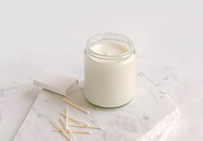 Soy candle in a clear glass jar with matches