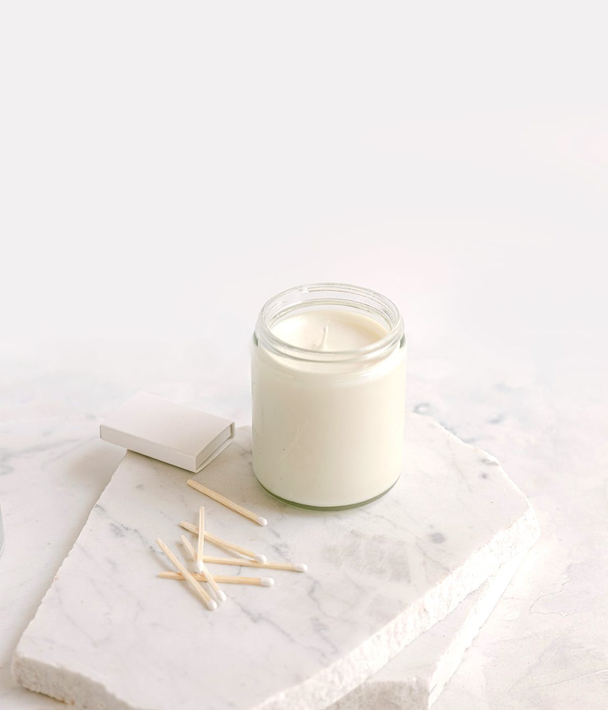 A hand-poured soy candle resting on a marble slab